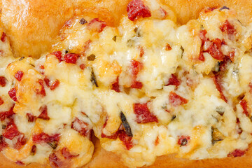 Pizza baguette top close-up, sausage and cheese, full depth of field