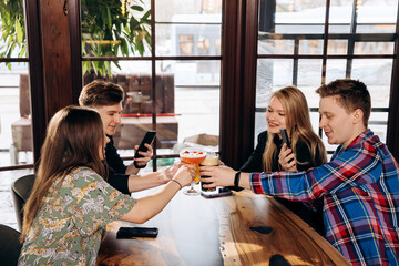Happy group of friends drinking and clinking with beer and cocktails at brewery bar restaurant. Beverage life style concept with guys and girls having fun together