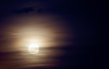 full moon behind clouds