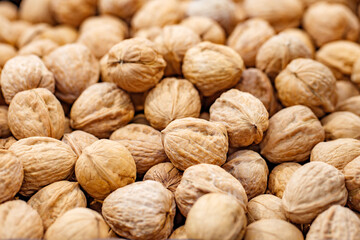 Walnuts unpeeled whole in bulk on market, selective focus