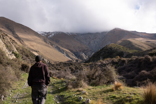 Man hiking through valley and mountain range