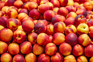 Nectarines red-orange whole in bulk on market, selective focus