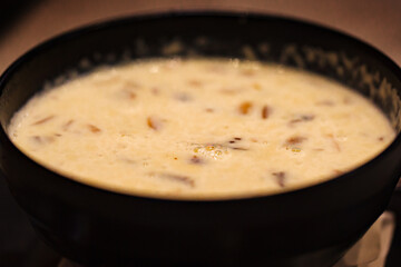 Mushroom cream soup in a dark bowl, selective focus