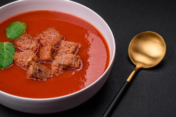 Delicious fresh gazpacho with breadcrumbs, salt and spices in a ceramic plate
