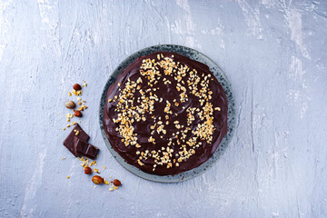 Traditional choco vanilla cake with chocolate icing chopped hazelnuts served as top view on a...