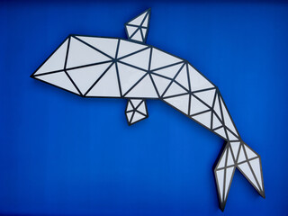 Decorative panel in the form of a whale on a blue wall
