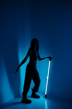 Young woman poses with light stick bar
