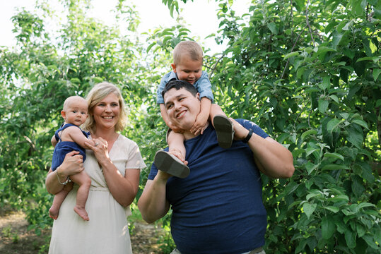 Happy smiling family with baby and toddler outdoors in summer - Powered by Adobe