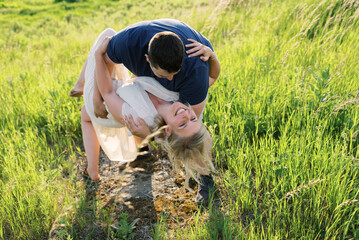 Laughing happy couple outdoors in field in summer