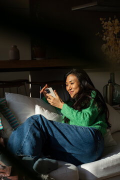 Happy woman using phone at home