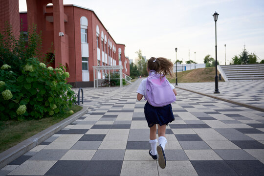 First-grader hurries to school on a scooter
