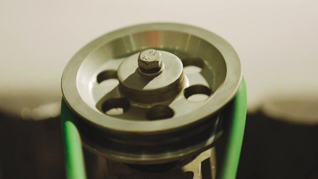 The glass enters the machine on rollers and undergoes a hardening process. The main gears that drive the machine rotate in the frame.