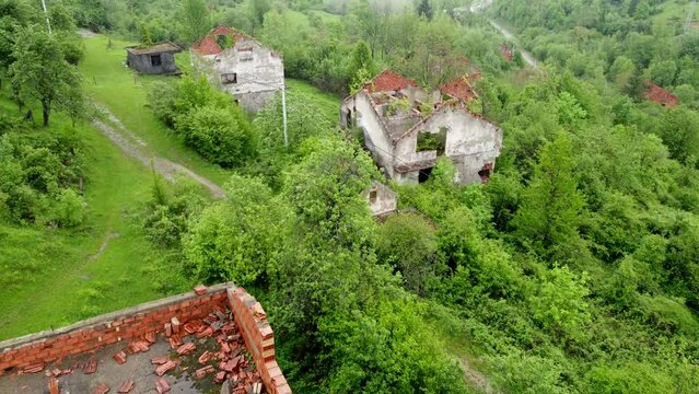 Destroyed houses in village as war aftermath, aerial drone view. Houses destroyed and burned by artillery during the war . Abandoned buildings. Houses in ruins. 