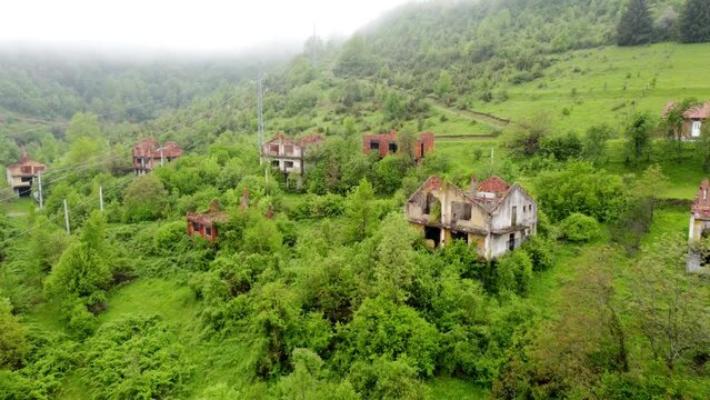 Destroyed houses in village as war aftermath, aerial drone view. Houses destroyed and burned by artillery during the war . Abandoned buildings. Houses in ruins. 