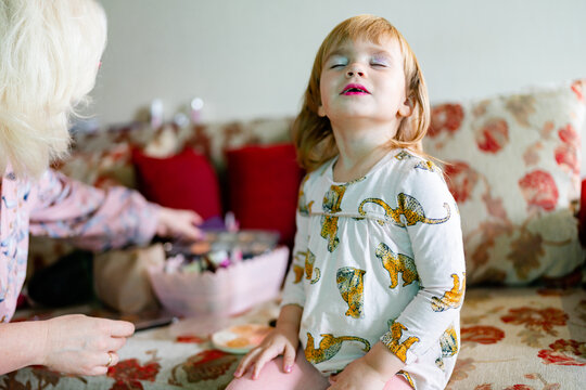 mother applying makeup her child