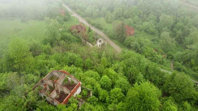 Destroyed houses in village as war aftermath, aerial drone view. Houses destroyed and burned by artillery during the war . Abandoned buildings. Houses in ruins. 