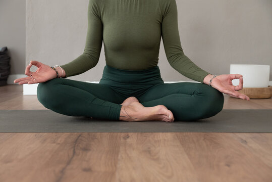 Crop woman meditating in lotus pose with mudra hands