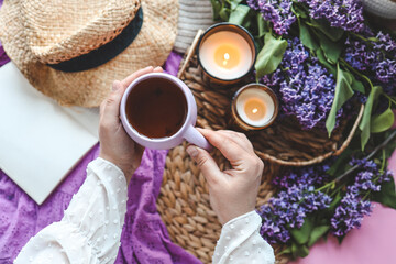 A cup of tea in hands on a background of lilac, top view, aesthetic photo