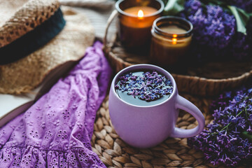 Cup of hot tea and lilac bouquet, good morning concept