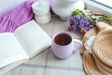 Cup of tea, straw hat and lilac basket, spring still life