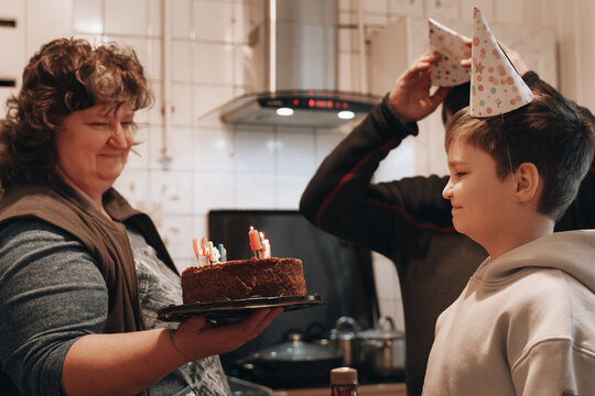 Happy Birthday teen gen z boy surrounded by dad mom blowing out candle