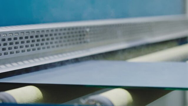 The glass goes into the machine on rollers and goes through the tempering process