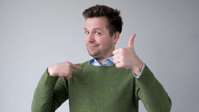 The European young man proudly points at himself, saying I am good with myself