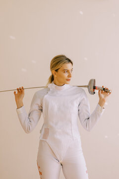 Young woman with white fencing uniform