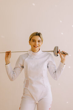 Happy  young woman with white fencing uniform