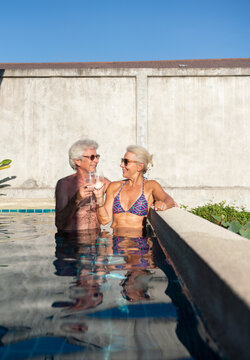 Candid Image Of Senior Couple Enjoying Drinks In The Pool 