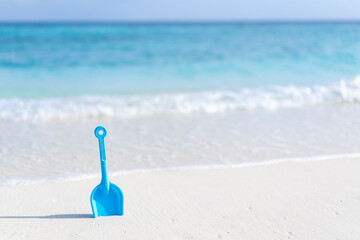 Fototapeta na wymiar Children's toy shovel on the beach against the background of the ocean in the Maldives.