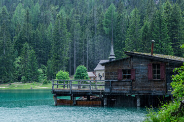 Fototapeta na wymiar Lago di Braies, Alto Adige, Italia, casetta in mezzo al lago e chiesa Kapelle 