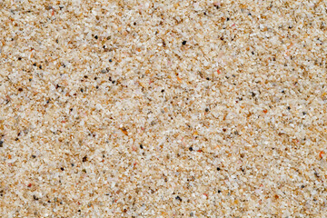 Background of sea yellow sand on the beach close-up, uniform texture