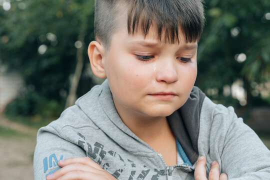 Desperate upset teen boy cries sitting on school backyard feels lonely