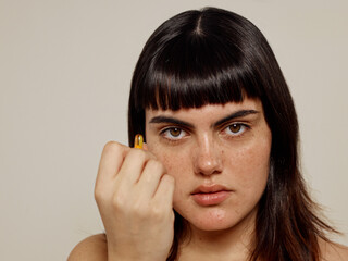 Woman holding natural ingredients capsule