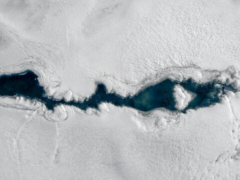 Aerial shot of a river in snow.