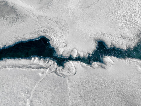 Aerial shot of a river in snow.