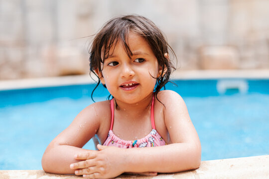 Charming little girl leaning on poolside