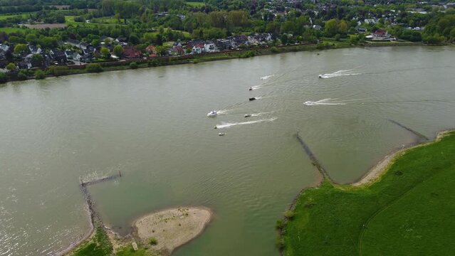 Drone shot of boats, speedboats, sailboats, ships and jetski in Hamm in Dusseldorf, Germany, on the Rhein river with the city skyline in the back, sailboats, boats