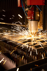 The fiber laser cutting machine cutting the sheet metal plate with the spark light