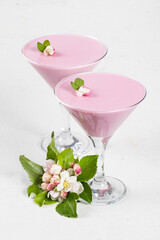 Vegan dessert. Pink tea matcha Panna Cotta in martini glass. Panna Cotta dessert with the addition of pink pitahaya powder. White background