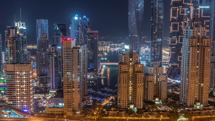 Fototapeta na wymiar Skyscrapers of Dubai Marina near intersection on Sheikh Zayed Road with highest residential buildings all night timelapse