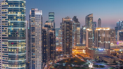 Fototapeta na wymiar Dubai's business bay towers aerial day to night timelapse. Rooftop view of some skyscrapers