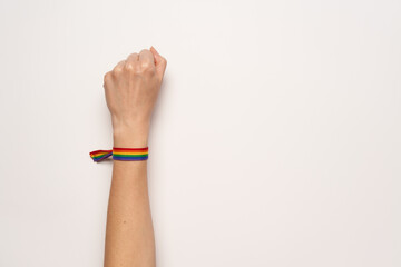 Fist fight of woman with LGBT rainbow bracelet on white background
