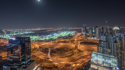 Panorama showing Dubai marina and JLT skyscrapers along Sheikh Zayed Road aerial night timelapse.