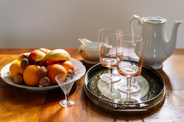 Fruit plate, goblet glasses on tray and ceramic pitcher arrangement 