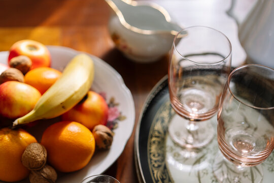 Detail of glasses on tray and a fruit plate on table.