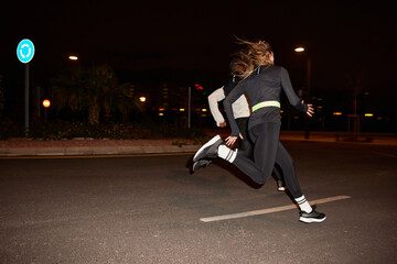 Energetic diverse people running together on street