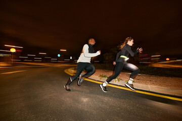Energetic diverse people running together on street