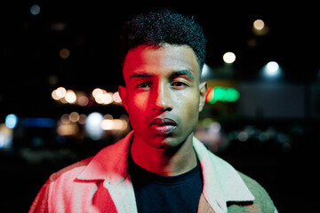 Man standing outdoors at night.